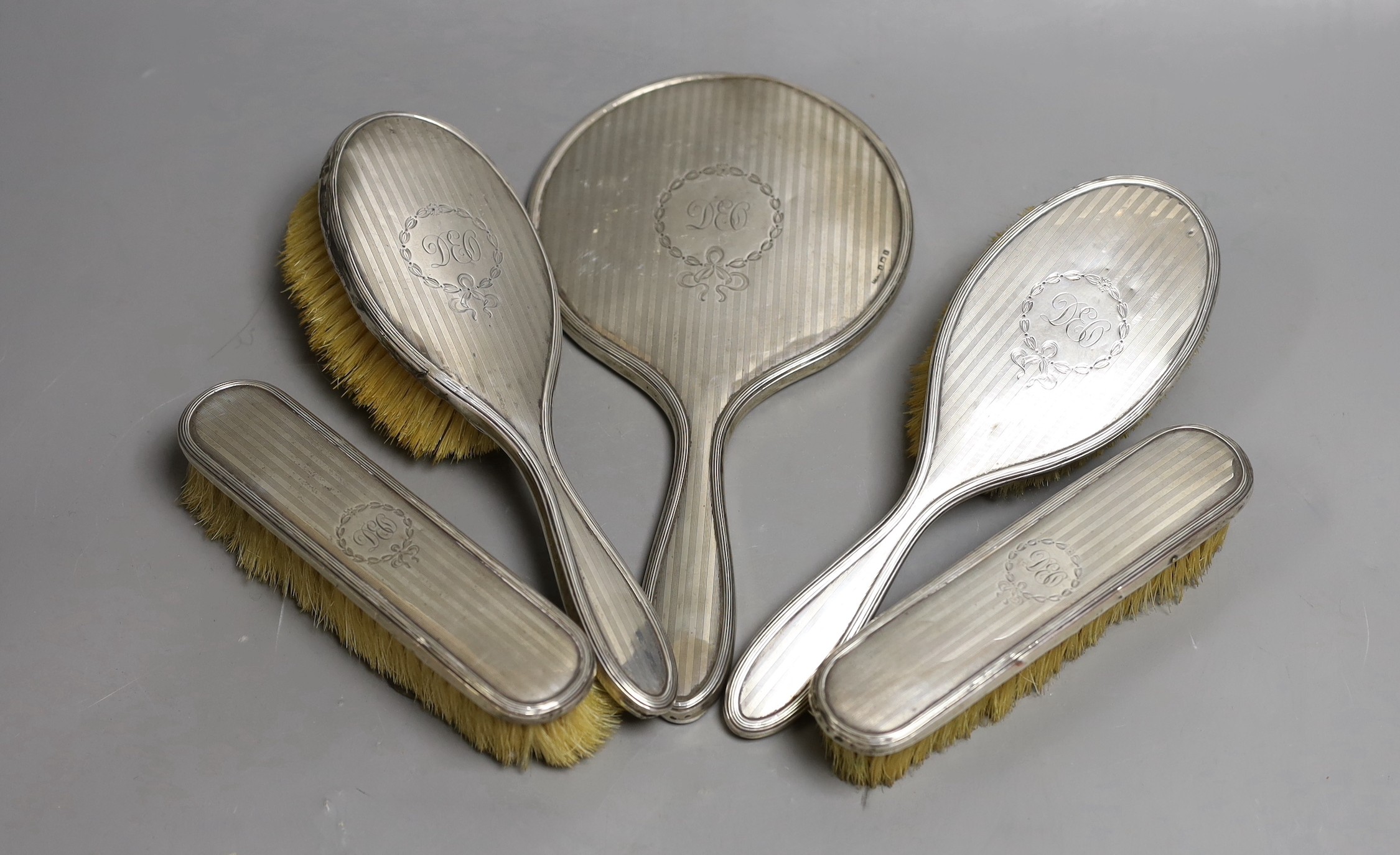 An Edwardian silver mounted five piece mirror and brush set, Birmingham, 1909.